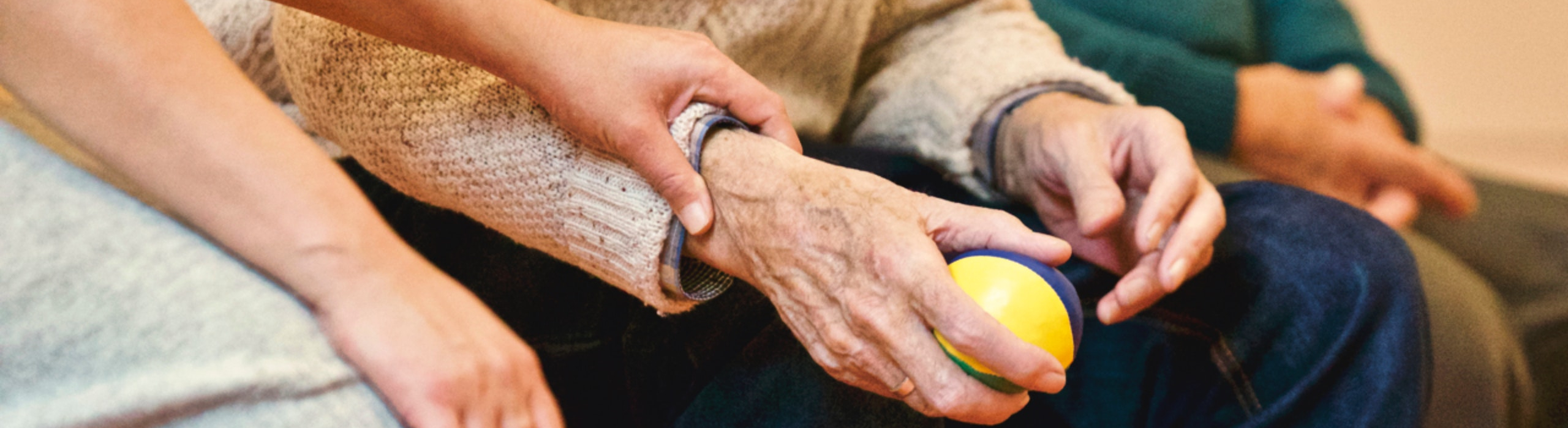 Hands of caregiver helping elderly person